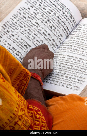 Il Nepal, Pashupatinath. Sadhu indù (asceta) Lettura scritture indù. Foto Stock