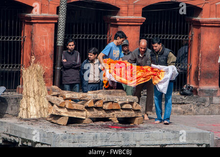 Il Nepal, Pashupatinath. Fasi di cremazione. I membri della famiglia preparare al posto del cadavere sul sito di cremazione. Foto Stock