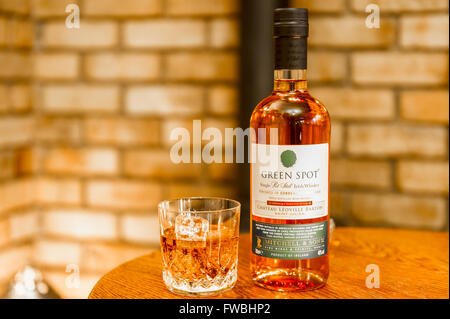 Bottiglia di whisky triplo distillato Green Spot con un bicchiere di whisky con cubetti di ghiaccio. Foto Stock