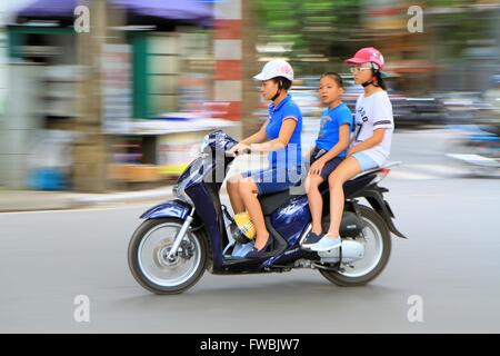 Famiglia vietnamita in sella a una moto ad Hanoi, in Vietnam, in Asia Foto Stock