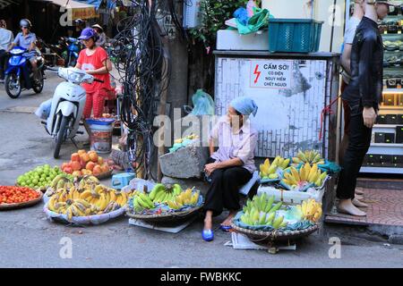 Signora Vietnamian vendono frutta fresca dal loro bicicletta nel quartiere vecchio di Hanoi, Vietnam Asia Foto Stock