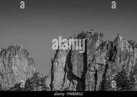 Arrampicatori prendendo una pausa sulla cima di una delle balze di Seneca Rocks in West Virginia, mostrato in bianco e nero Foto Stock