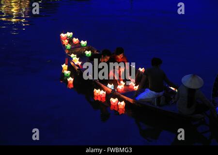 Coppia giovane disperdendo le candele sulla superficie del fiume di notte, Hoi An, Vietnam Asia Foto Stock