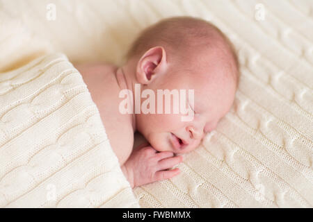 Piccolo neonato dormire su un soffice coltre di maglia Foto Stock