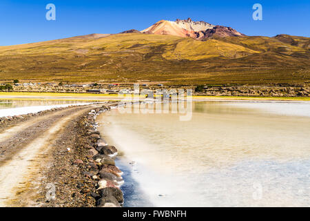 Vulcano dormiente e il lago salato a Salar de Uyuni, Bolivia Foto Stock