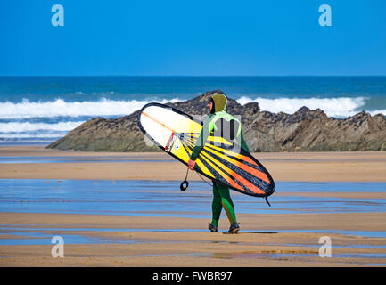Un modo cosciente surfer il Fistral Beach in Newquay, Cornwall, England, Regno Unito Foto Stock
