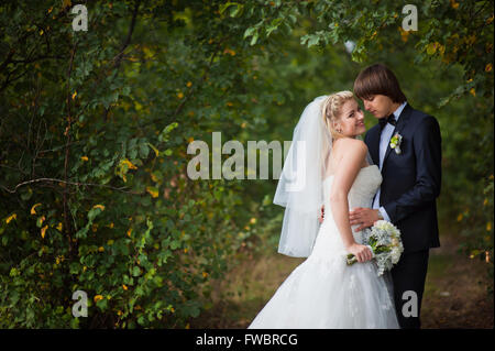 Sposa e lo sposo in piedi nel parco Foto Stock