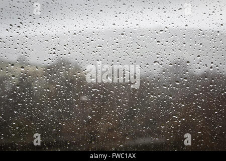 Gocce di pioggia su una finestra durante il tempo umido Foto Stock