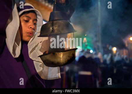 Un ragazzo si sparge incenso a Gesù Nazareno del jordon processione durante la pasqua settimana santa in Antigua Guatemala. Settimana Santa (Seman Foto Stock