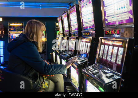 Lone donna giocando un jackpot macchina in un casinò. Foto Stock