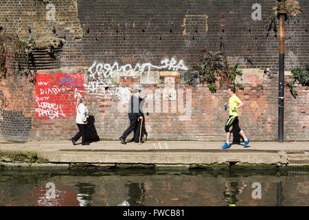 La gente che camminava sul Regent's Canal alzaia in London King's Cross district, England, Regno Unito Foto Stock