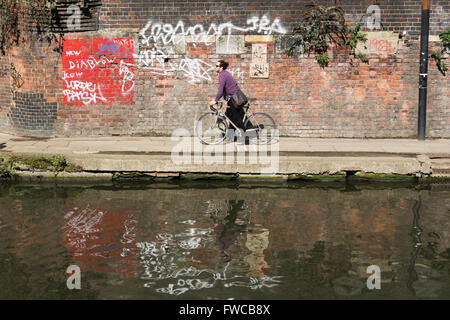 Un maschio solitario ciclista sul Regent's Canal alzaia in London King's Cross district, England, Regno Unito Foto Stock