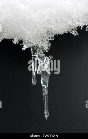 Icicle formata dalla fusione di neve che ricoprono un patio con tavolo Foto Stock