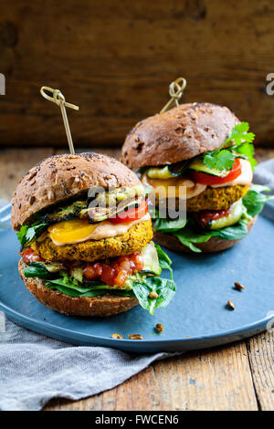 La zucca e i ceci burger con salsa di pomodoro, spinaci, arrosto di zucchine e avocado Foto Stock