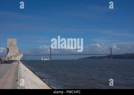 Il Monumento delle Scoperte con il XXV Aprile ponte dietro, Lisbona, Portogallo. Foto Stock