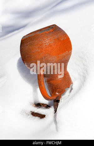 Vecchia Caraffa in ceramica appesa alla recinzione in inverno Foto Stock