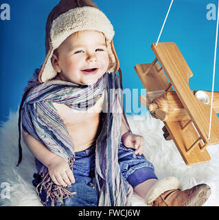 Ridere piccolo ragazzo con un aeroplano giocattolo Foto Stock