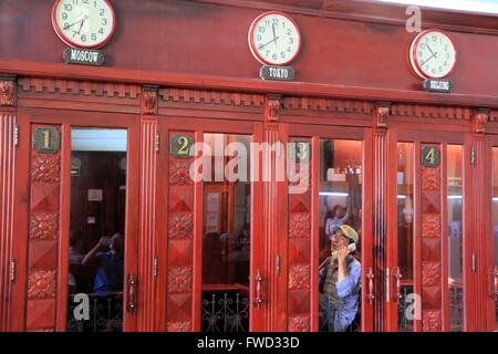 Uomo che parla al telefono in una cabina telefonica presso il Central post office a Saigon, Vietnam Asia Foto Stock