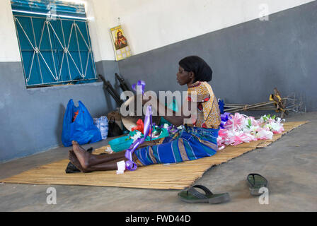 Lacekocot, distretto di Pader, Uganda. 2009. Gli uomini e le donne nella chiesa al Lacekocot sfollati interni nel campo di Pader rendere nastri e addobbi floreali per un matrimonio. La chiesa fu costruita per la trib Acholi che vivono sul campo e mettere in pratica il cristianesimo. Il gruppo di sedersi su un coloratissimo tappeto sul pavimento di cemento. Foto Stock