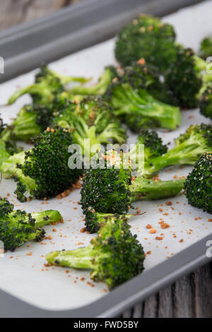 Cotto arrosto parmigiano aglio e olio di oliva broccoli lato piatto sul tavolo in legno Foto Stock