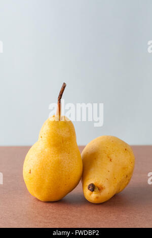 Due interi giallo pere Corella su una superficie di legno. L'immagine verticale con copia spazio. Foto Stock
