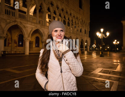 Passeggiata serale a Venezia vi portano in un altro mondo. Felice giovane donna tourist permanente sulla Piazza San Marco vicino Dogi Palac Foto Stock