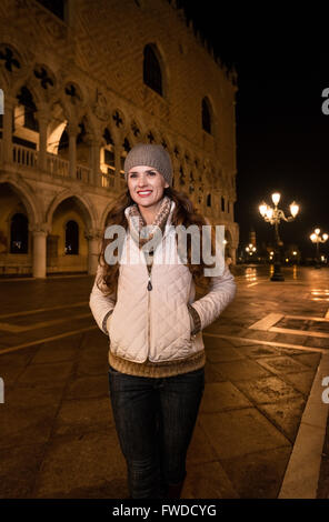 Passeggiata serale a Venezia vi portano in un altro mondo. Felice giovane donna tourist permanente sulla Piazza San Marco vicino Dogi Palac Foto Stock