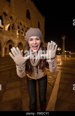 Passeggiata serale a Venezia vi portano in un altro mondo. Allegro giovane donna turistico a Piazza San Marco in serata shouti Foto Stock