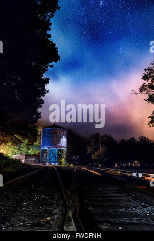 Una nebbia atmosferica versa su un water tower, che racchiude il cielo stellato vicino alla vecchia ferrovia vie in Cass, West Virginia. Foto Stock