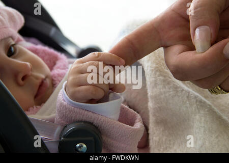 A Belgrado, in Serbia - cinque mesi di età Baby girl holding alla nonna dito Foto Stock