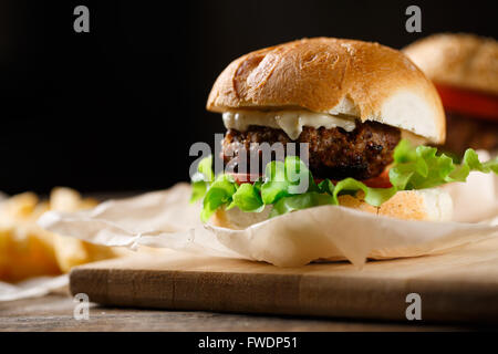 In casa gustosi hamburger e patatine fritte sul tavolo di legno Foto Stock