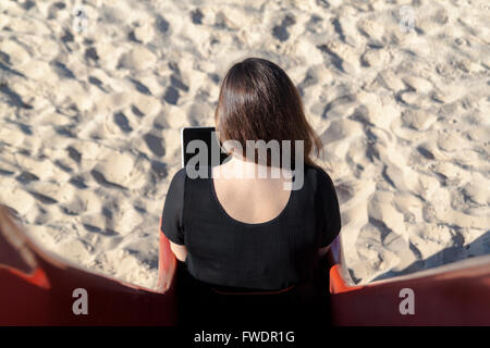 Donna seduta su una diapositiva Foto Stock