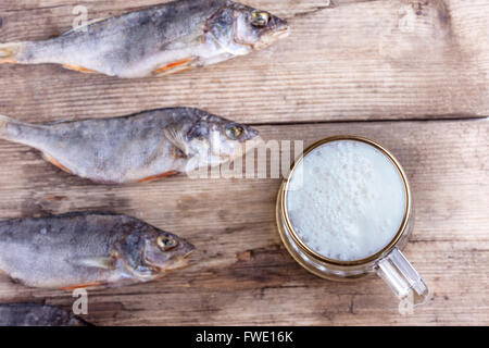 Boccale di birra e pesce essiccato sul tavolo Foto Stock