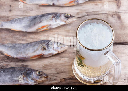 Boccale di birra e pesce essiccato sul tavolo Foto Stock