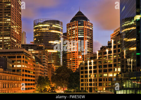 Close-up penetrazione nella giungla di cemento della grande città di Sydney al Tramonto tra alti grattacieli di torri e palazzi di uffici. Foto Stock