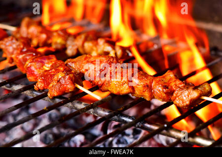 Primo piano di alcuni spiedini di carne alla griglia essendo in un barbecue Foto Stock