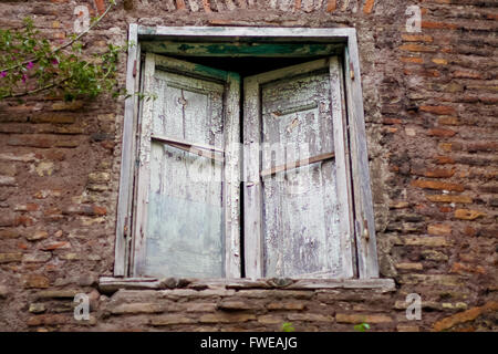 Chiuso vecchia finestra con persiane rotto Foto Stock