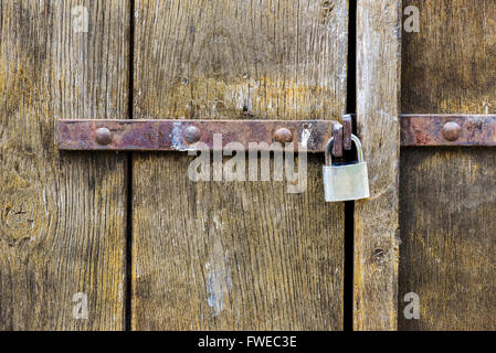 Porta di legno con lucchetto in acciaio di luce naturale Foto Stock