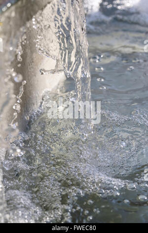 Dettaglio di una fontana dalla quale sgorga acqua limpida Foto Stock