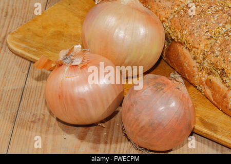 Cipolline, cipolle, verdure su un tagliere di legno Foto Stock