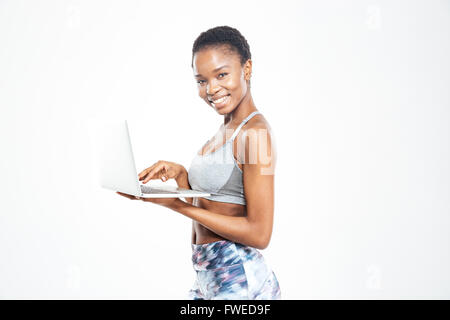 Ritratto di felice attraente giovane americano africano sportive con il computer portatile su sfondo bianco Foto Stock