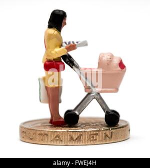 Un singolo miniaturizzato femmina figurina genitore con una carrozzina in piedi su un cancelletto coin Foto Stock