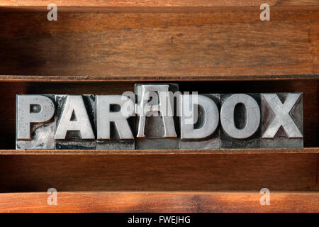 Paradosso parola fatta da metallico tipo di stampa in rilievo sul vassoio in legno Foto Stock