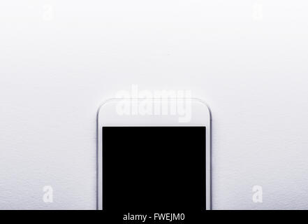 Smart phone prevista su bianco scrivania da ufficio, spazio di copia Foto Stock
