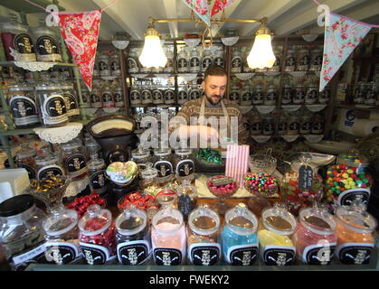 Titolare, David Walker che serve all'interno di 'Edward & Vintage'; il suo negozio di dolci Tissington village, Peak District Derbyshire UK UE Foto Stock