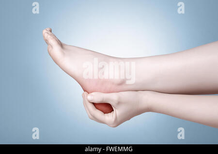 Una giovane donna massaggiare la sua dolorosa tacco Foto Stock