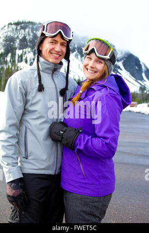 Una coppia felice insieme sul resort di montagna nella neve per una giornata di sci e snowboard. Foto Stock