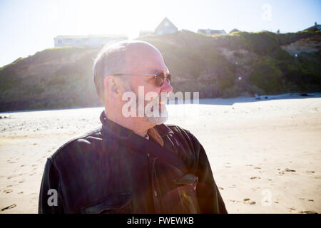 Un attraente padre si affaccia alla sua destra mentre il fotografo prendere un ritratto a colori durante le riprese nella luce del sole di crea Foto Stock