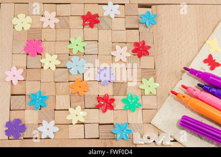 Marrone blocchi in legno con fiori colorati Foto Stock