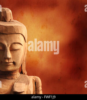 Metà di legno Buddha faccia su Grunge sfondo Foto Stock